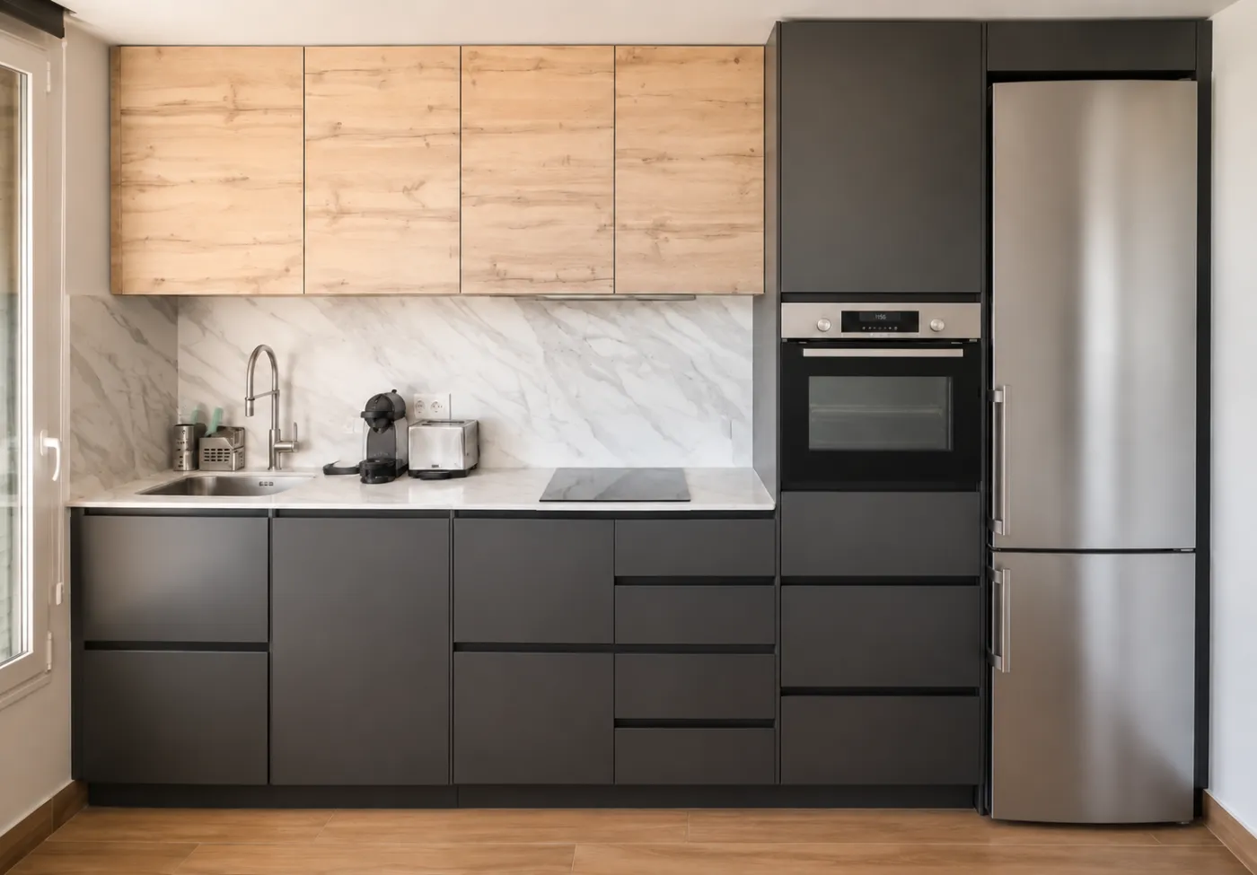 Una cocina compacta abierta al salón mediante un cerramiento plegable